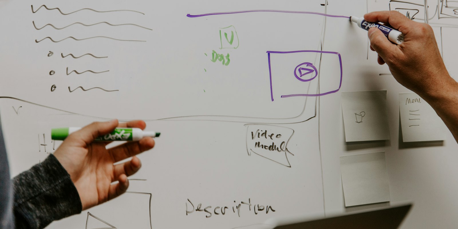 Two people mapping ideas on a whiteboard