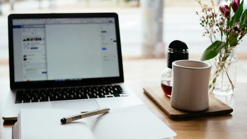 Laptop beside an open notebook for studying