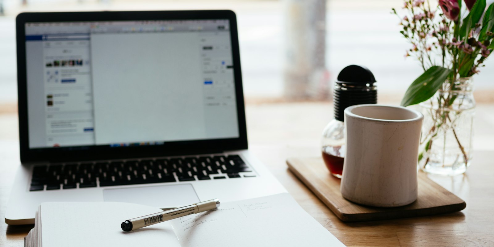 Laptop beside an open notebook for studying