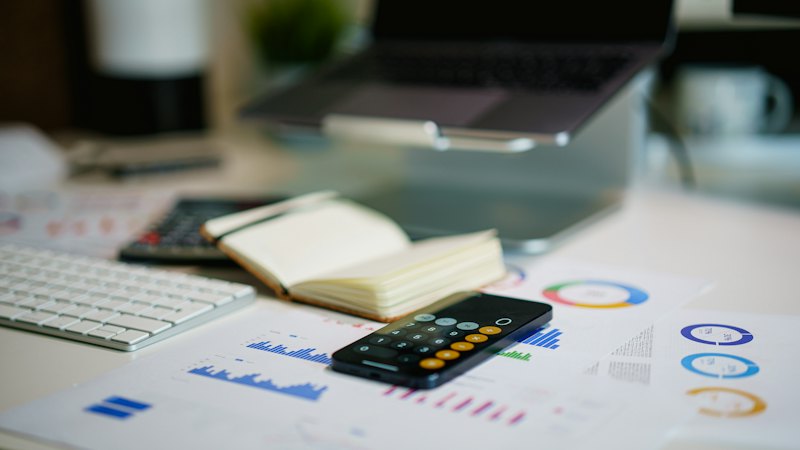 Office desk with smartphone and financial charts