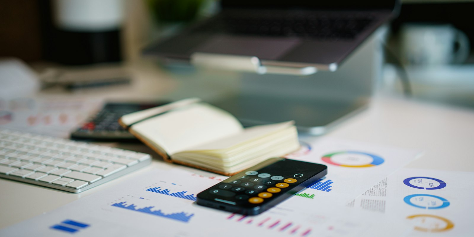 Office desk with smartphone and financial charts