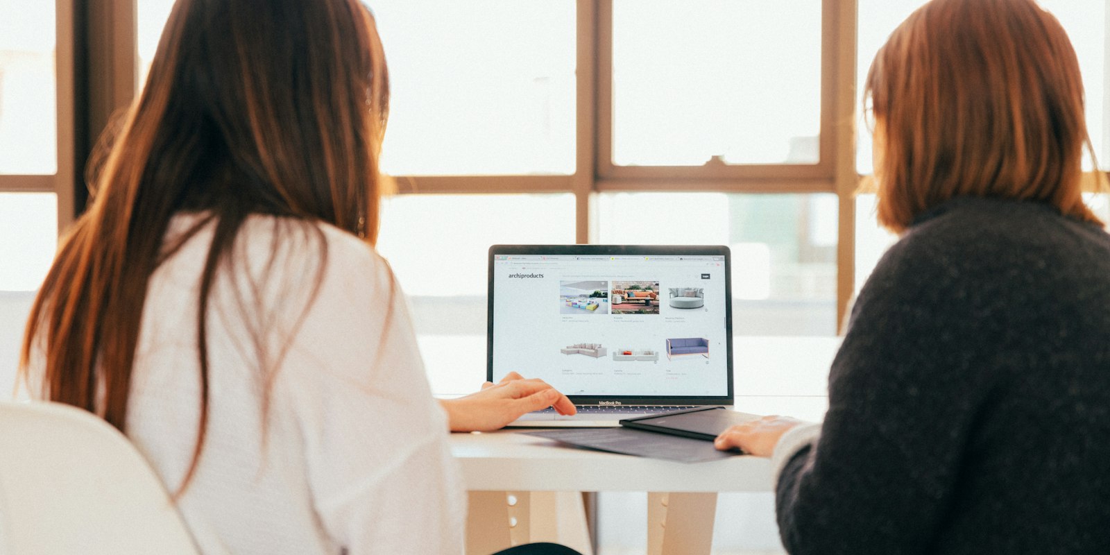 Two colleagues discussing work on a laptop