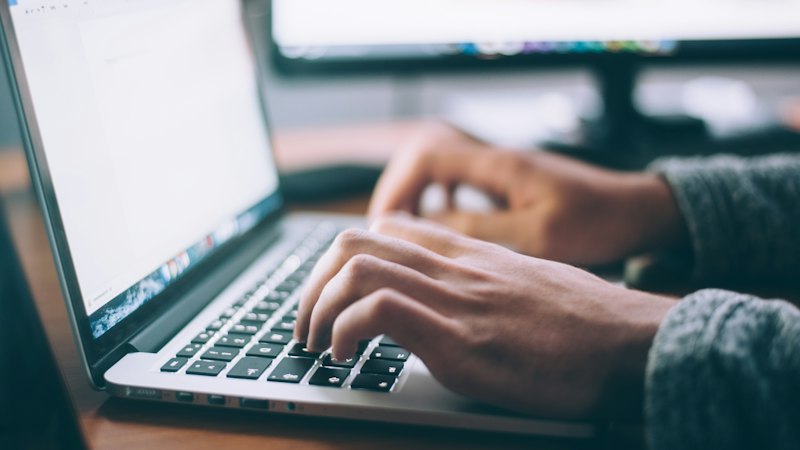 Person working on a laptop at a desk